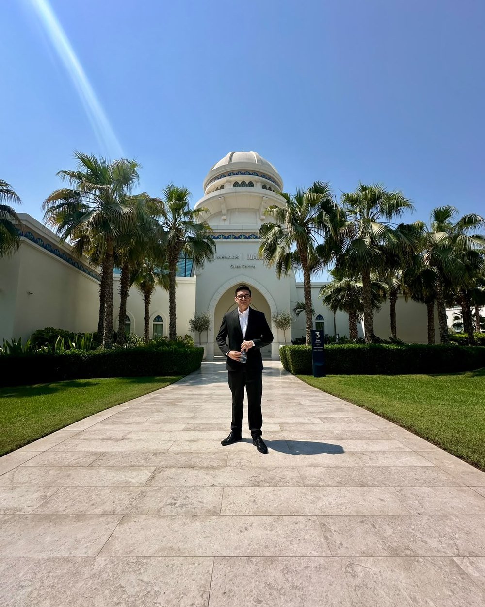 Gilber Garzón, asesor inmobiliario colombiano certificado en Dubái, frente al centro de ventas de un proyecto